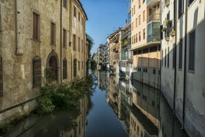 A narrow canal flanked by historic buildings with arched windows and balconies.
