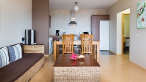 Eine moderne Küche mit Essbereich, einer Couch und einem Kühlschrank.