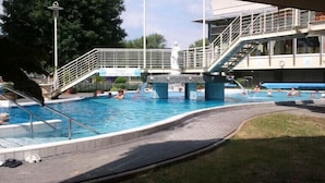 A swimming pool with a diving platform, steps, and a lifeguard stand. - Pension Carmen (Bad Hoenningen)