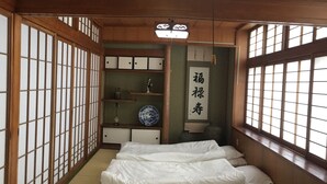 Et traditionelt japansk rum med tatamimåtter, shoji-skærme og en futon-seng.