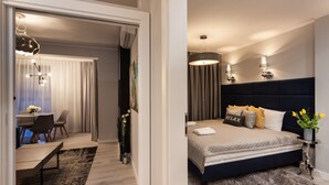Un dormitorio moderno con una cama grande, lámparas de noche y vistas a un comedor con mesa y sillas.