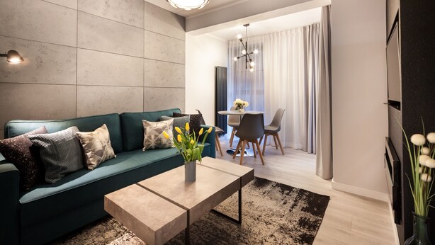 Una sala de estar moderna con un sofá color turquesa, una mesa de centro y un comedor con una mesa y sillas.