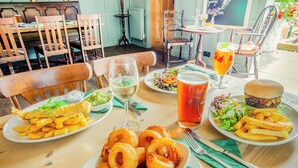 A dining table with plates of food, drinks, and cutlery. - Minnie - Tiger Inn (Eastbourne)
