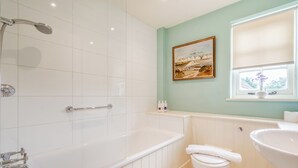 A bathroom with a bathtub, toilet, and sink. - Minnie - Tiger Inn (Eastbourne)