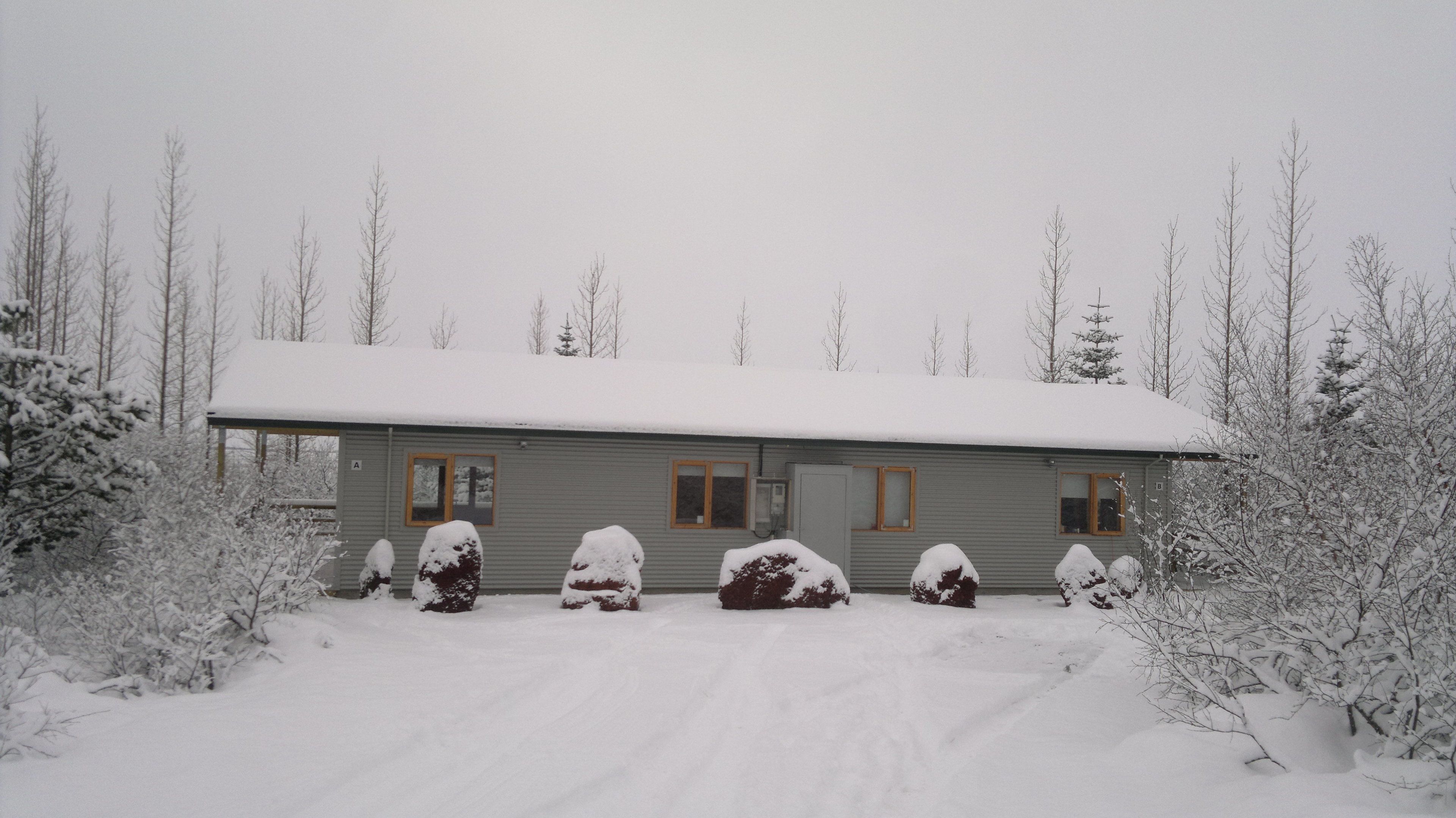 A single-story building with a snow-covered roof and a front porch.