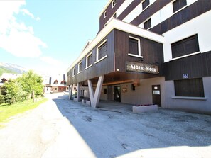 A building with a sign reading "AIGLE NOIR" and a wheelchair accessibility symbol.