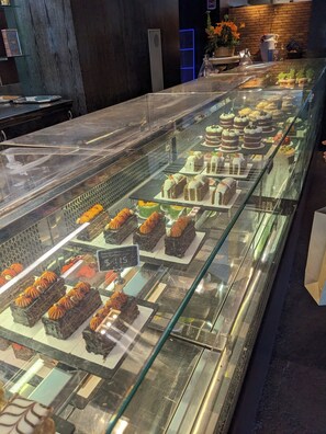 Une vitrine de boulangerie où sont exposés divers gâteaux et pâtisseries.