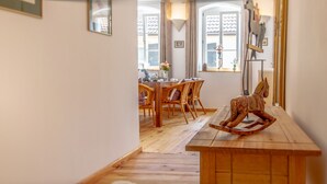 Uma sala de jantar com mobiliário de madeira e um cavalinho de balanço.