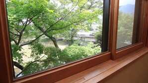 A window with a view of a tree and a building. - Yufuin Yamaboushi (Yufu)