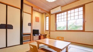 A traditional Japanese room with tatami flooring, a low table, and a television. - Yufuin Yamaboushi (Yufu)