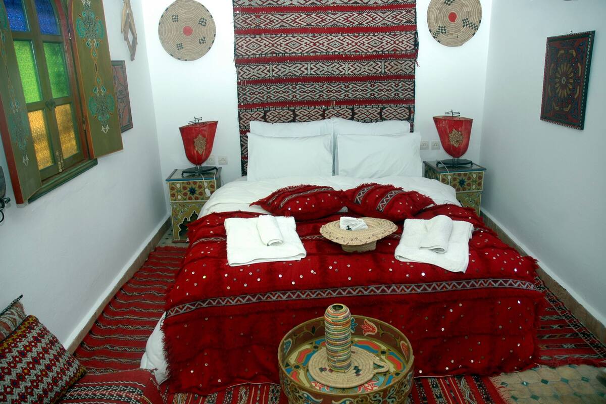 A traditional room with a bed, patterned textiles, and decorative items.