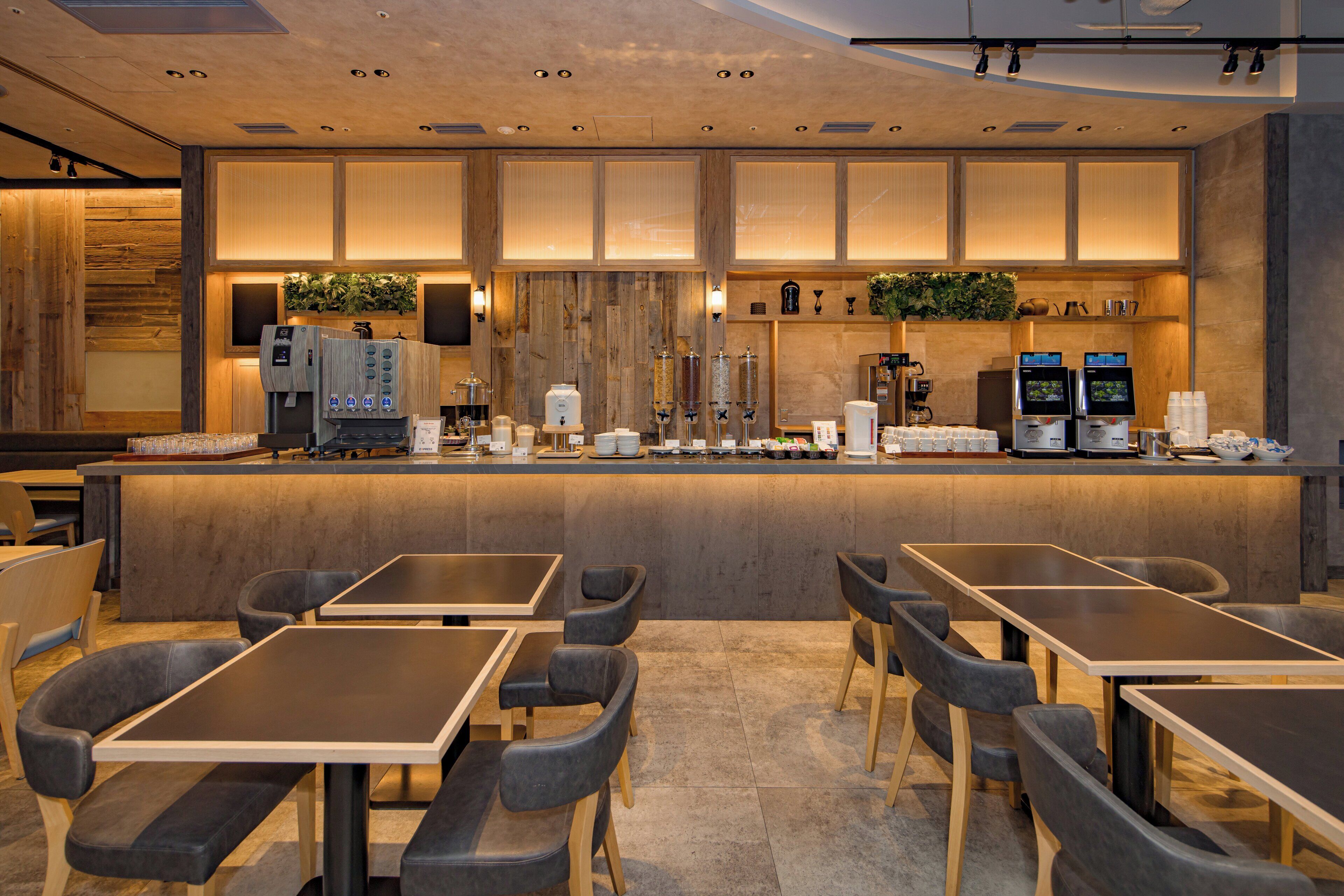A modern bar area with seating and a coffee machine.