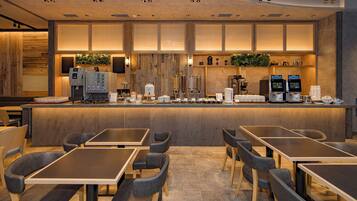 A modern bar area with seating and a coffee machine.