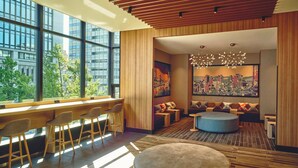 Un interior moderno con un amplio ventanal, mobiliario de madera y vistas a la ciudad.