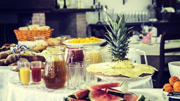 Un bufé de desayuno con diversas frutas, pasteles y bebidas.