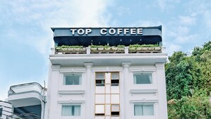 Un hotel con un letrero que indica "Lang Chai Hotel" y "Top Coffee" sobre la entrada.