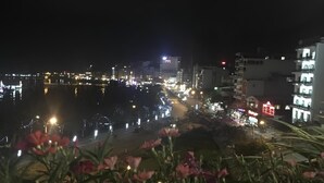 Un paisaje urbano nocturno con edificios iluminados y un río.