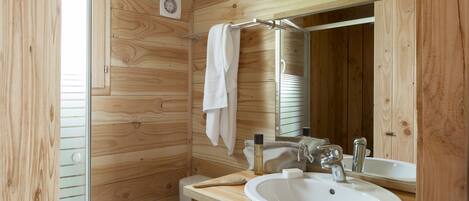 A wooden-paneled bathroom with a white sink, a mirror, and a towel hanging on a rack.