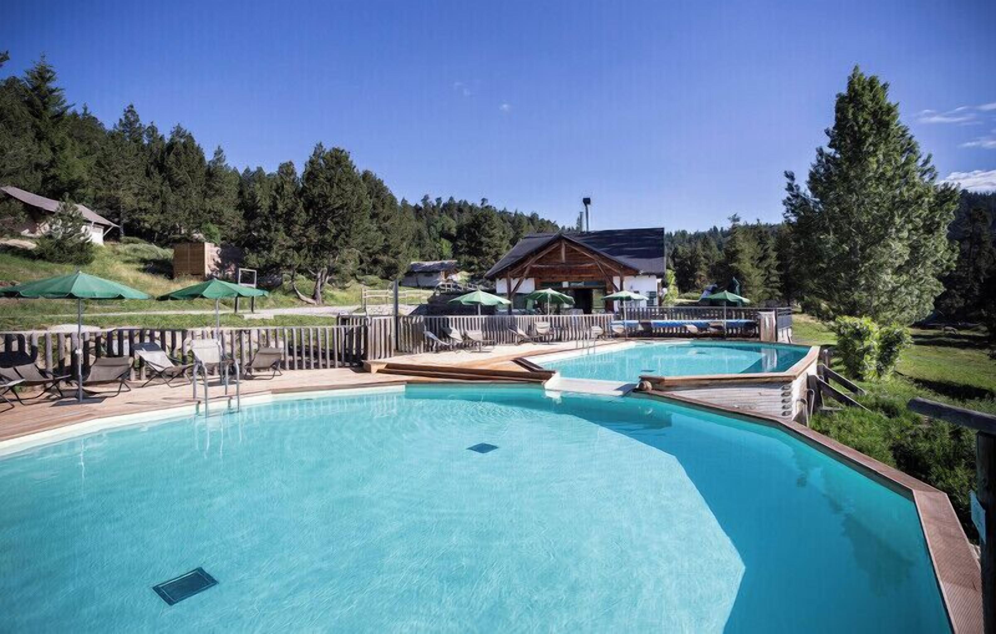 Una piscina al aire libre de temporada, sombrillas