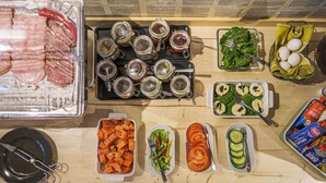 Ett buffébord med olika sorters mat, inklusive kött, grönsaker och tillbehör.