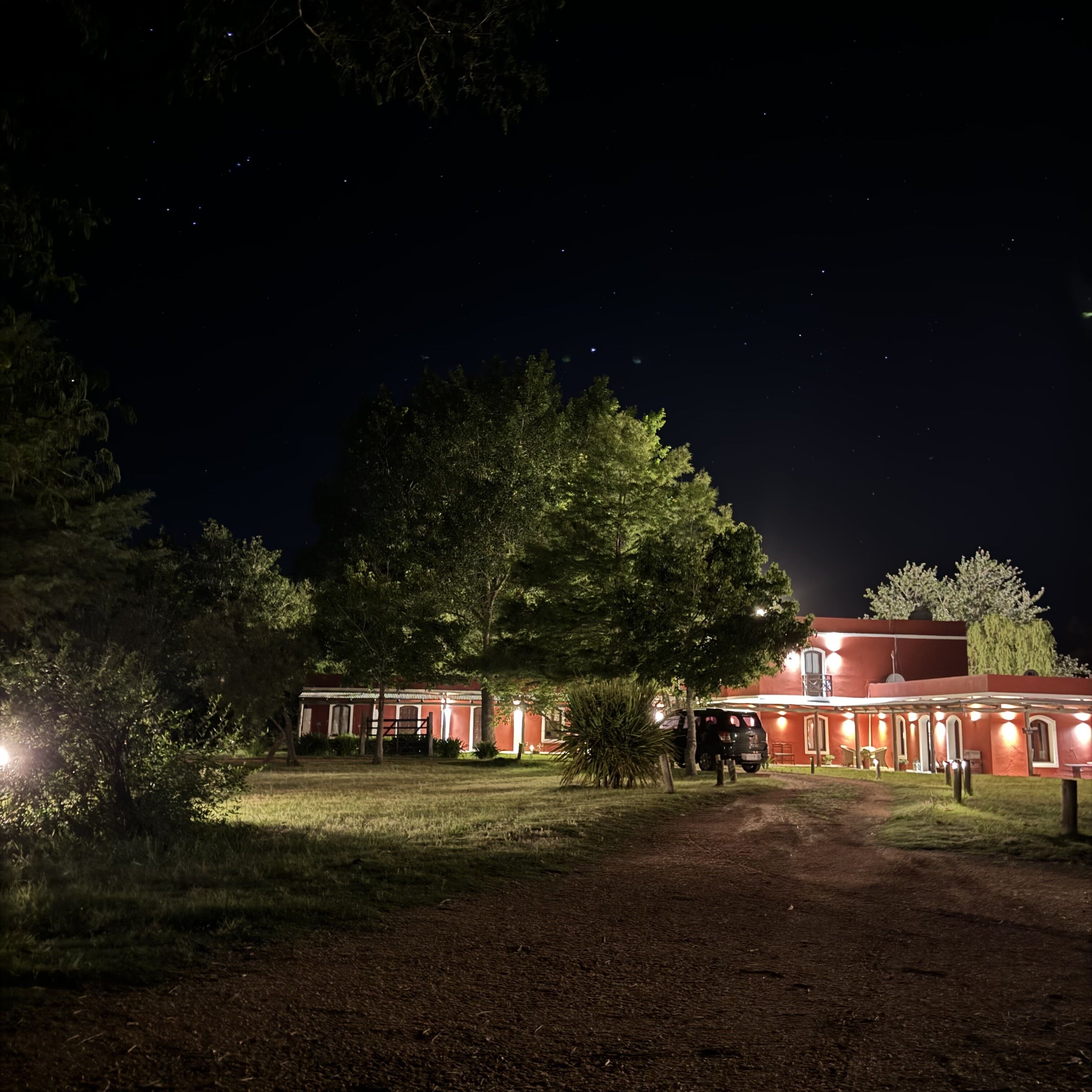 Un edificio con facciata rossa, circondato da alberi e un'area verde.