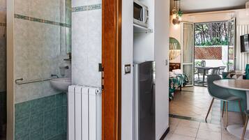 Una cocina moderna con microondas integrado, un fregadero y una zona de comedor con mesa y sillas.