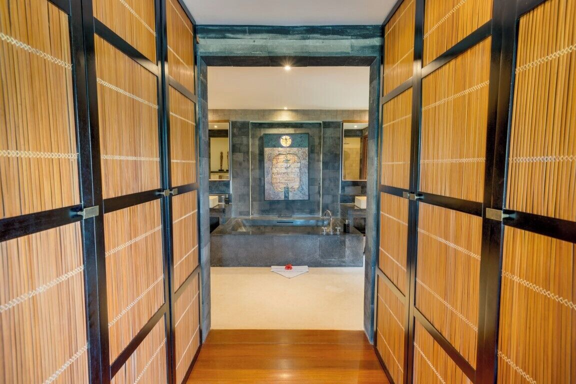 A hallway with wooden paneling and a central area with a sink and a decorative wall piece.