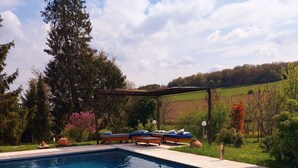 Une piscine avec des chaises longues et une pergola.