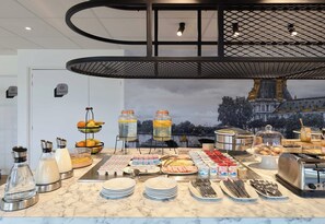 A buffet setup with various food items and condiments, a water dispenser, and a toaster. - B&B HOTEL Paris Vitry-sur-Seine 3 étoiles (Vitry-sur-Seine)