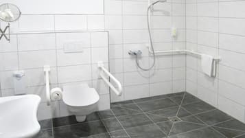Une salle de bain moderne équipée de toilettes, d’un bidet et d’une douche.