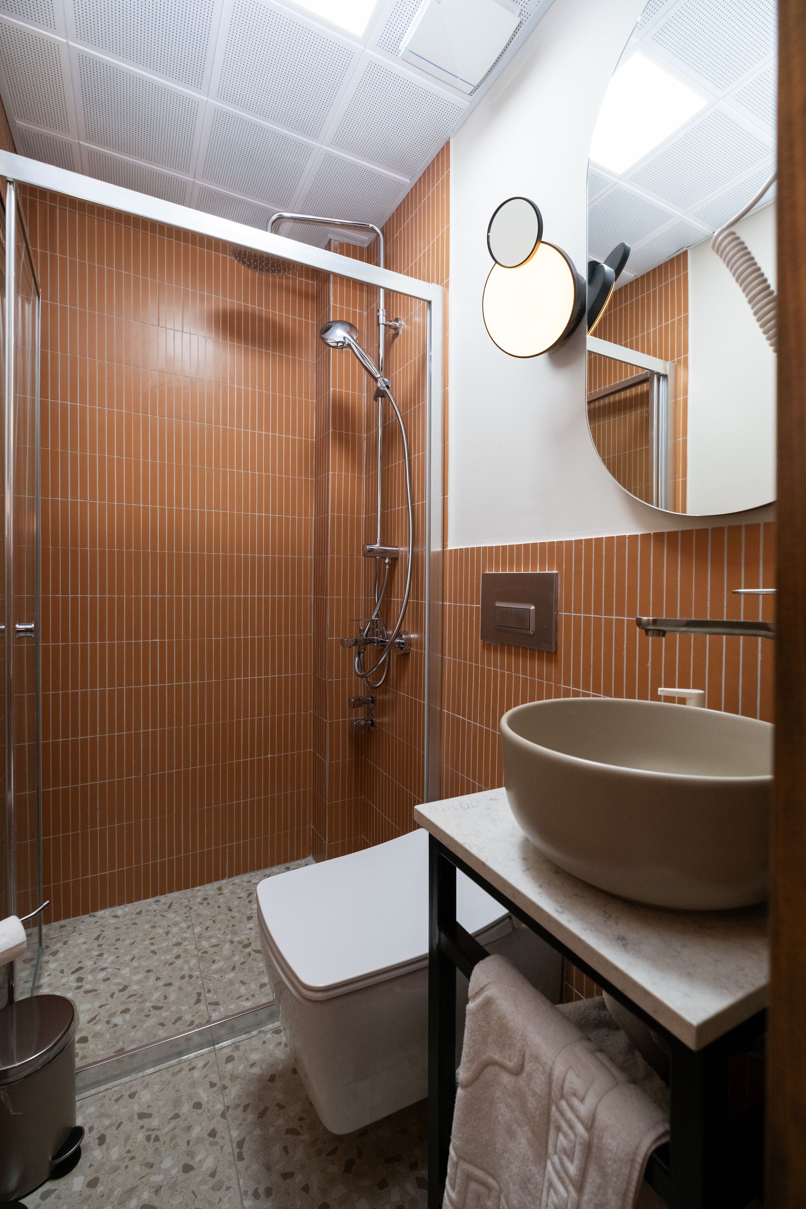 A modern bathroom with a large sink, a toilet, and a shower area.