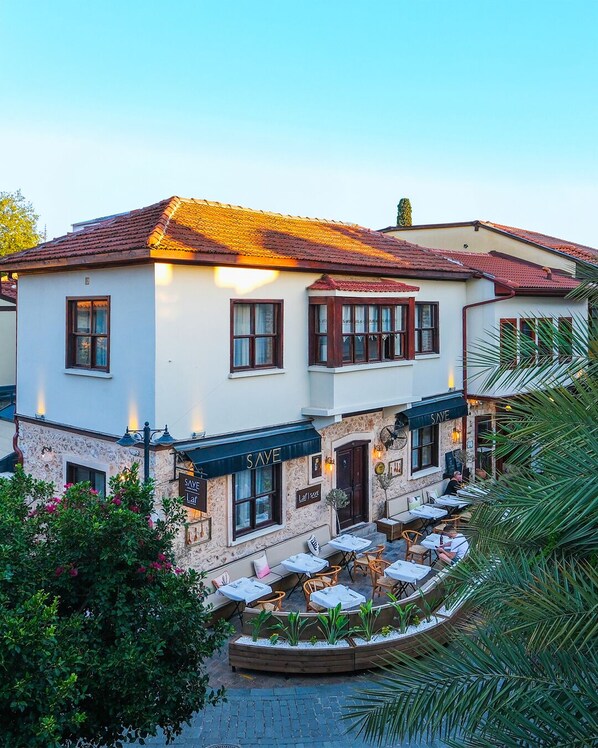A two-story building with a tiled roof and a ground floor with outdoor seating. - Saye Konak Kaleiçi&Oldtown (Antalya)