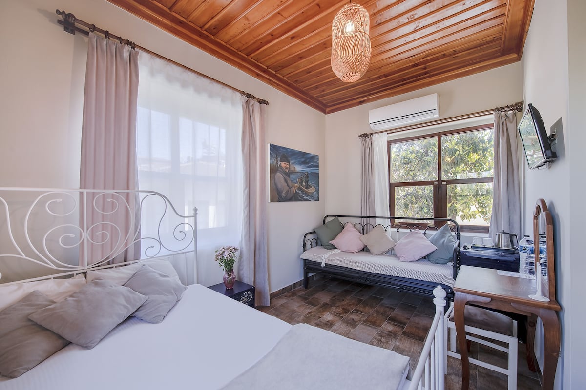 A bedroom with a bed, bedside table, and a desk with a chair.