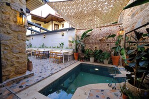 A pool area with a tiled floor, a small pool, and surrounding plants. - Saye Konak Kaleiçi&Oldtown (Antalya)