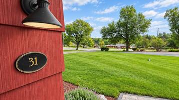 A red building with a black mailbox and a house number plaque.