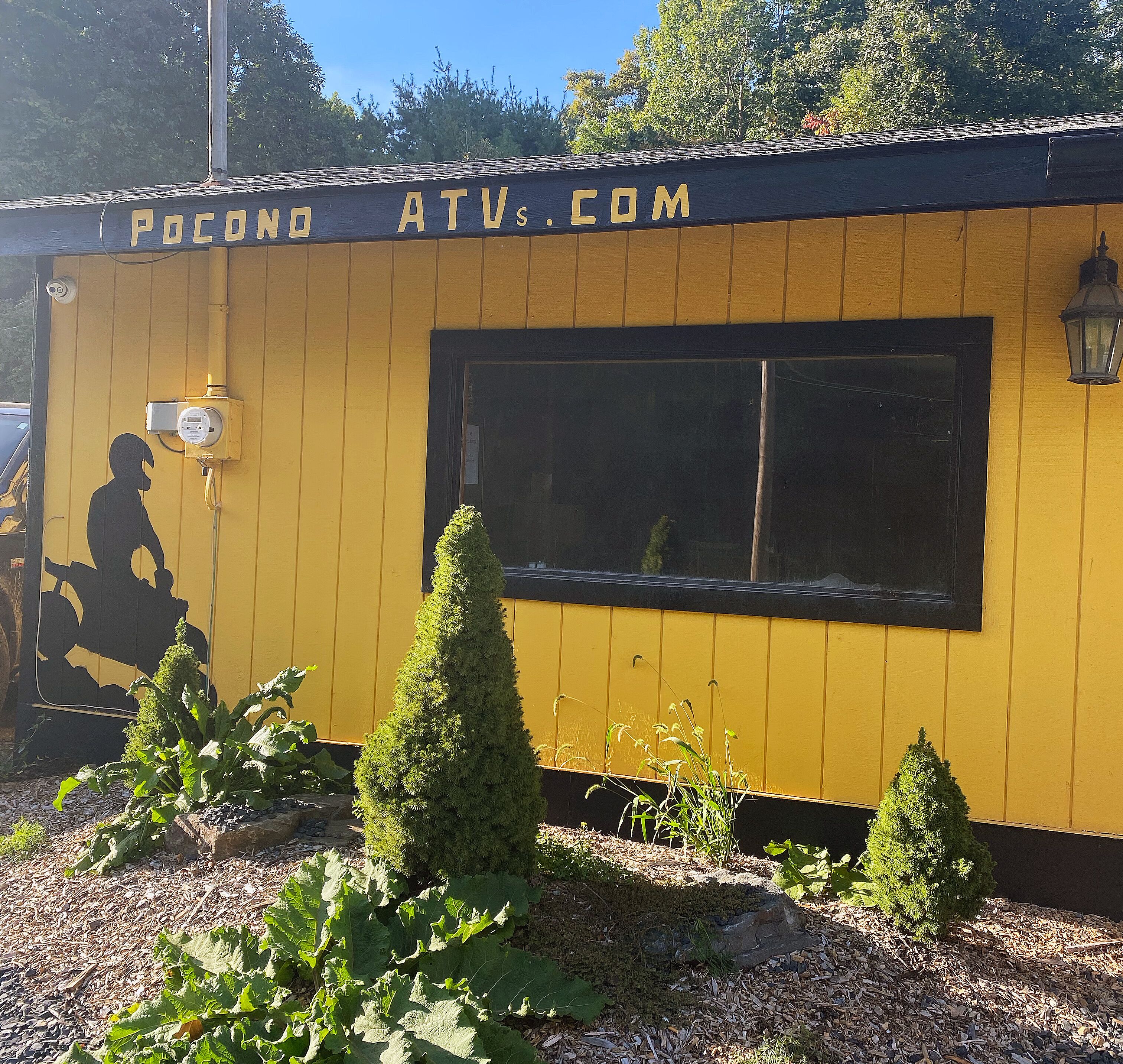 A yellow building with a sign reading "POCONDO ATV.COM".