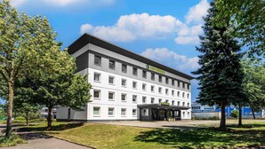 Un hotel modern amb teulada plana, nombroses finestres i entrada coberta.