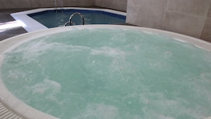 A large indoor hot tub with a metal ladder, surrounded by tiled walls. - Interpass Golf Playa Country Club (Isla Cristina)