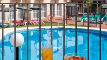 Una piscina cubierta, una piscina al aire libre de temporada, sombrillas