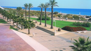 A coastal promenade with palm trees, benches, and a clear view of the ocean. - Interpass Golf Playa Country Club (Isla Cristina)