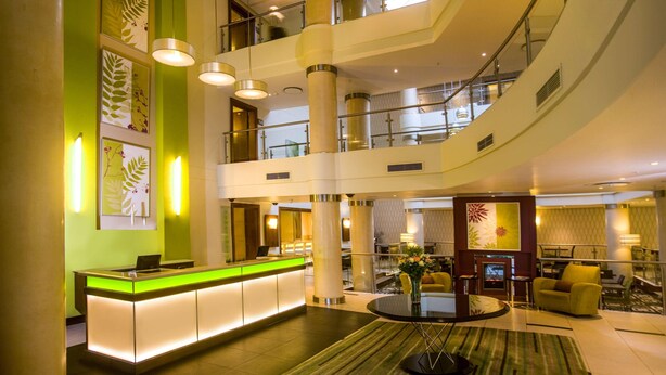 A hotel lobby with a reception desk, multiple floors, and a central atrium. - Stayeasy Pietermaritzburg (Pietermaritzburg)