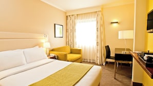 A hotel room with a large bed, a desk, a chair, and a television. - Stayeasy Pietermaritzburg (Pietermaritzburg)