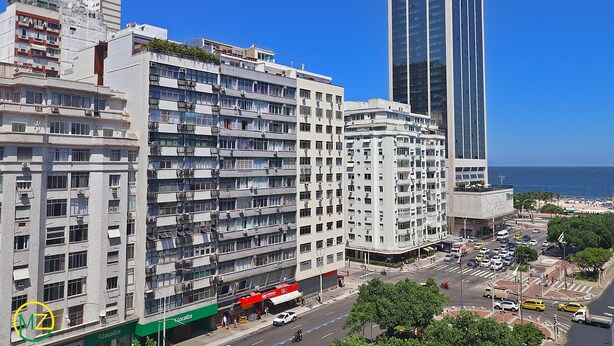 Ein mehrstöckiges Hotel mit Balkonen, Meerblick und Parkplätzen.