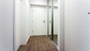 A narrow hallway with white walls and a wooden floor. - Lugo Apartments (Split)