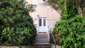 A set of stone steps leading to a white door with a blue sign above it. - Lugo Apartments (Split)