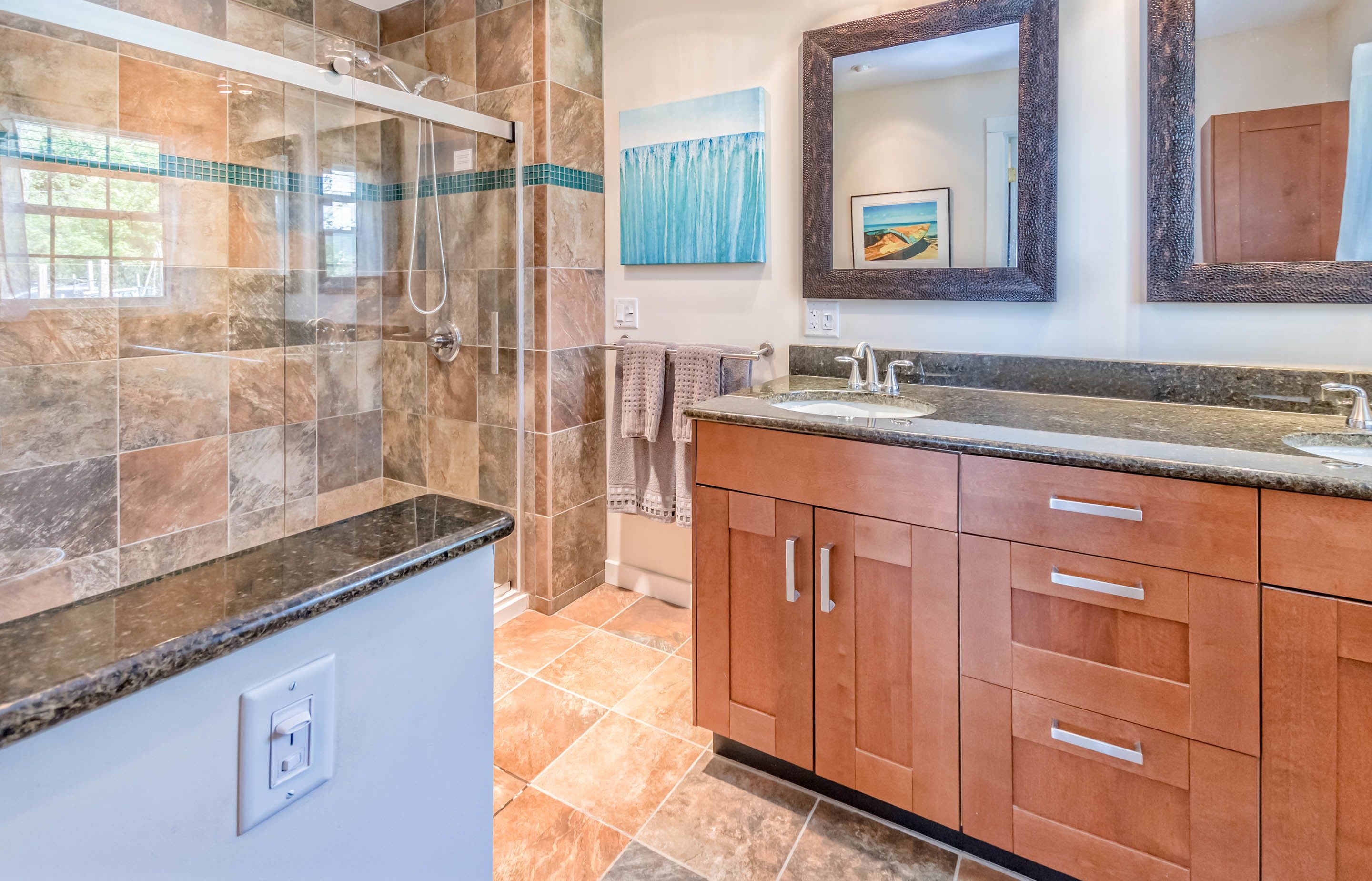 A bathroom with a shower, a sink with a mirror, and a towel rack.
