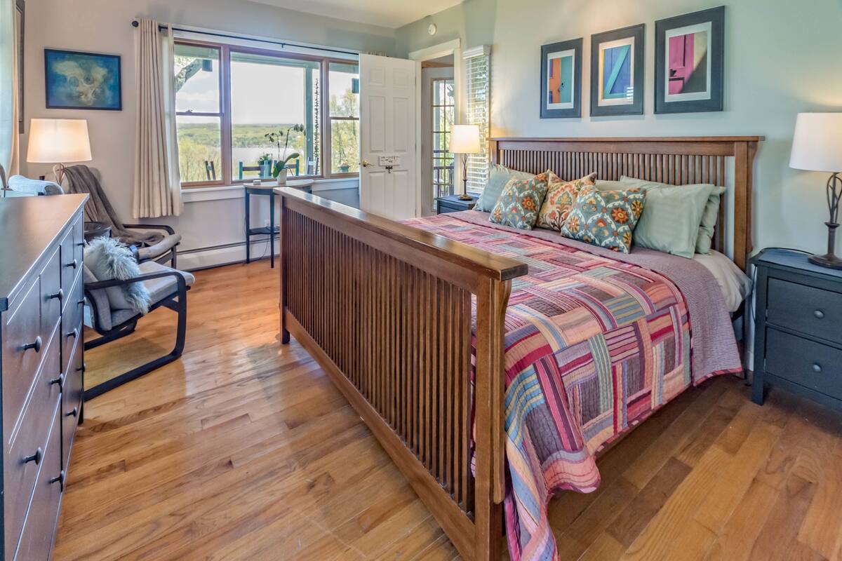 A bedroom with a wooden bed, a desk, and a chair.