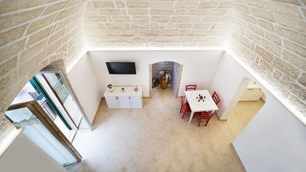 A compact room with a TV, a small table with chairs, and a white cabinet.