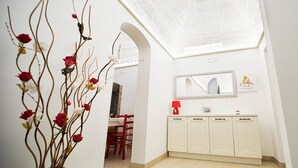 A modern bathroom with a white vanity, a mirror, and a vase with branches and flowers.