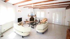 A spacious living room with a fireplace, two sofas, a coffee table, and a TV.